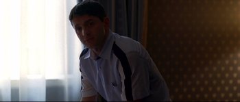 Movie still from “Gomorrah” (2008), directed by Matteo Garrone – A man in a white and black shirt looking at the camera; Medium shot, Low angle