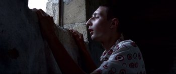 Movie still from “Gomorrah” (2008), directed by Matteo Garrone – A young man holding a piece of paper in front of his face; Close Up shot, Low angle