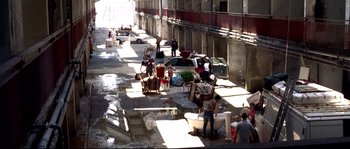 Movie still from “Gomorrah” (2008), directed by Matteo Garrone – A group of people standing on the side of a road; Extreme Wide shot, High angle