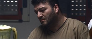 Movie still from “Gomorrah” (2008), directed by Matteo Garrone – A person with a beard; Close Up shot, Over the shoulder angle