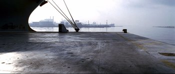 Movie still from “Gomorrah” (2008), directed by Matteo Garrone – A dock with a large ship in the background; Extreme Wide shot, High angle