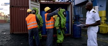 Movie still from “Gomorrah” (2008), directed by Matteo Garrone – A group of people in protective suits and hard hats; Medium shot, High angle