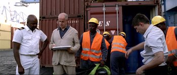 Movie still from “Gomorrah” (2008), directed by Matteo Garrone – A group of men wearing hard hats and orange vests; Medium shot, Low angle