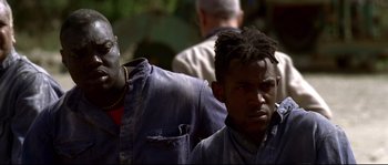 Movie still from “Gomorrah” (2008), directed by Matteo Garrone – Two men are standing next to each other; Close Up shot, Low angle