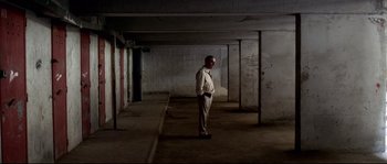 Movie still from “Gomorrah” (2008), directed by Matteo Garrone – A man standing in an empty room in a building; Wide shot, High angle
