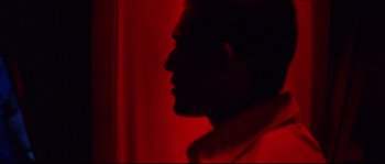 Movie still from “Gomorrah” (2008), directed by Matteo Garrone – A man in a red room with his head turned to the side; Close Up shot, Low angle