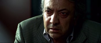 Movie still from “Gomorrah” (2008), directed by Matteo Garrone – An older man is looking into the camera; Close Up shot, Over the shoulder angle