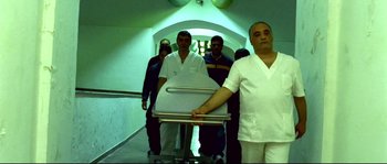 Movie still from “Gomorrah” (2008), directed by Matteo Garrone – A group of men standing in a hallway next to each other; Wide shot, Low angle