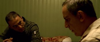 Movie still from “Gomorrah” (2008), directed by Matteo Garrone – An older man sitting on top of a bed next to a wall; Close Up shot, Over the shoulder angle