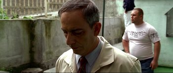 Movie still from “Gomorrah” (2008), directed by Matteo Garrone – A person wearing a suit and tie; Close Up shot, Over the shoulder angle