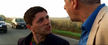 Movie still from “Gomorrah” (2008), directed by Matteo Garrone – Two men talking on the side of a road; Close Up shot, Over the shoulder angle