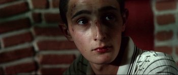 Movie still from “Gomorrah” (2008), directed by Matteo Garrone – A young person with a bruise on his face; Close Up shot, High angle