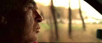 Movie still from “Gomorrah” (2008), directed by Matteo Garrone – An old man with a beard looking into the distance; Extreme Close Up shot, Low angle