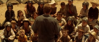 Movie still from “Gone in 60 Seconds” (2000), directed by Dominic Sena – A group of children sitting in a circle with a man in the foreground; Wide shot, High angle