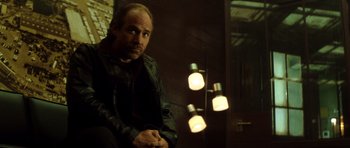 Movie still from “Gone in 60 Seconds” (2000), directed by Dominic Sena – A man sitting in front of some lights in a room; Medium shot, Low angle