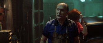 Movie still from “Gone in 60 Seconds” (2000), directed by Dominic Sena – An older man wearing an apron looking up at something; Close Up shot, Low angle