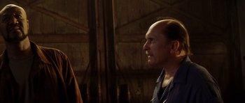 Movie still from “Gone in 60 Seconds” (2000), directed by Dominic Sena – A man with a bald head looking to his left; Close Up shot, Over the shoulder angle