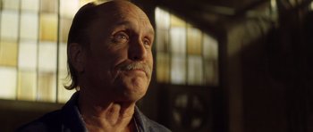 Movie still from “Gone in 60 Seconds” (2000), directed by Dominic Sena – An old man with a mustache looking upward; Close Up shot, Low angle