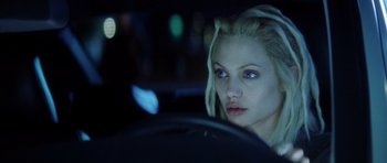 Movie still from “Gone in 60 Seconds” (2000), directed by Dominic Sena – A woman sitting in the driver's seat of a car at night; Close Up shot, Over the shoulder angle