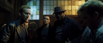 Movie still from “Gone in 60 Seconds” (2000), directed by Dominic Sena – A group of men standing next to each other in front of a window; Medium shot, Low angle