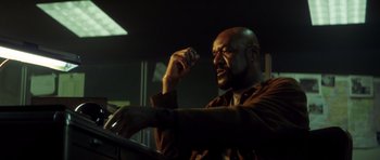 Movie still from “Gone in 60 Seconds” (2000), directed by Dominic Sena – A man with a beard is leaning on a railing; Close Up shot, Low angle