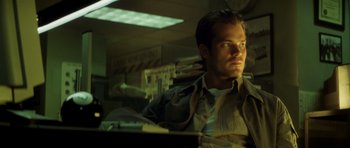 Movie still from “Gone in 60 Seconds” (2000), directed by Dominic Sena – A man sitting at a desk in front of a laptop computer; Close Up shot, Low angle