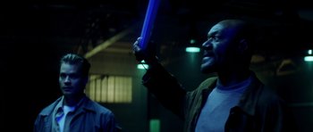 Movie still from “Gone in 60 Seconds” (2000), directed by Dominic Sena – A man holding a blue object in his hand; Medium shot, Low angle