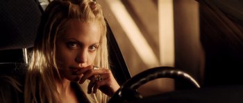 Movie still from “Gone in 60 Seconds” (2000), directed by Dominic Sena – A woman sitting behind a steering wheel while smoking a cigarette; Close Up shot, Over the shoulder angle