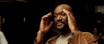 Movie still from “Gone in 60 Seconds” (2000), directed by Dominic Sena – A man with a beard is holding his hand up to his face; Close Up shot, Low angle