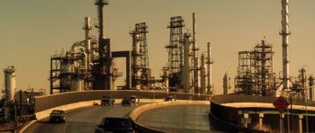 Movie still from “Gone in 60 Seconds” (2000), directed by Dominic Sena – Cars driving down a highway near a refinery; Extreme Wide shot, Low angle