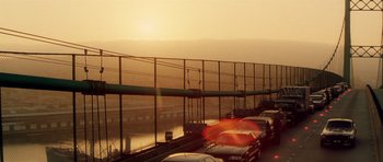 Movie still from “Gone in 60 Seconds” (2000), directed by Dominic Sena – Cars are parked on a bridge near a body of water at sunset; Extreme Wide shot, High angle
