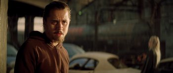 Movie still from “Gone in 60 Seconds” (2000), directed by Dominic Sena – A man standing in front of a car in a parking lot; Close Up shot, Over the shoulder angle