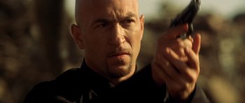 Movie still from “Gone in 60 Seconds” (2000), directed by Dominic Sena – A man with a bald head holding a cell phone in his hand; Close Up shot, Low angle