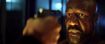 Movie still from “Gone in 60 Seconds” (2000), directed by Dominic Sena – A person holding a gun in his hand; Close Up shot, Low angle