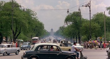 Movie still from “Good Morning, Vietnam” (1987), directed by Barry Levinson – A busy street filled with lots of cars and people on bikes; Extreme Wide shot, Low angle