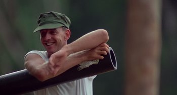 Movie still from “Good Morning, Vietnam” (1987), directed by Barry Levinson – A man holding a baseball bat in his hand; Medium shot, Low angle