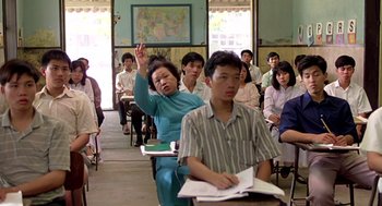 Movie still from “Good Morning, Vietnam” (1987), directed by Barry Levinson – An older woman raises her hand in front of an older man; Medium shot, High angle