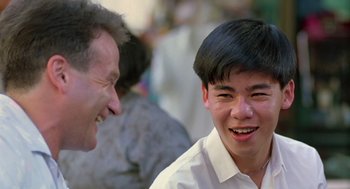 Movie still from “Good Morning, Vietnam” (1987), directed by Barry Levinson – Two men are smiling and talking to each other; Close Up shot, Over the shoulder angle
