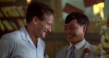 Movie still from “Good Morning, Vietnam” (1987), directed by Barry Levinson – A couple of men standing next to each other; Close Up shot, Over the shoulder angle