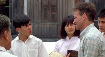 Movie still from “Good Morning, Vietnam” (1987), directed by Barry Levinson – A man and two women talking to each other outside; Medium shot, Over the shoulder angle