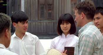 Movie still from “Good Morning, Vietnam” (1987), directed by Barry Levinson – A group of people standing next to each other on a street; Medium shot, Over the shoulder angle