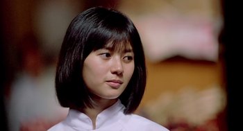 Movie still from “Good Morning, Vietnam” (1987), directed by Barry Levinson – A young woman with a black hair style; Close Up shot, Low angle