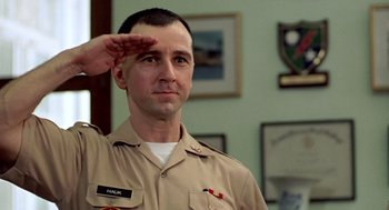 Movie still from “Good Morning, Vietnam” (1987), directed by Barry Levinson – A man saluting while wearing a military uniform; Close Up shot, Low angle