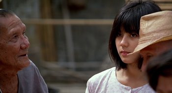 Movie still from “Good Morning, Vietnam” (1987), directed by Barry Levinson – A young woman with short black hair wearing a white shirt; Close Up shot, Over the shoulder angle