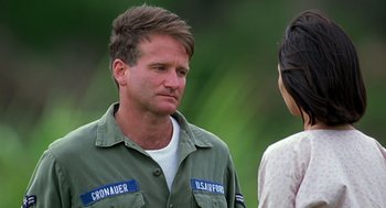 Movie still from “Good Morning, Vietnam” (1987), directed by Barry Levinson – A man in a military uniform talking to a woman in a white shirt; Close Up shot, Over the shoulder angle