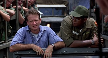 Movie still from “Good Morning, Vietnam” (1987), directed by Barry Levinson – Two men sitting on the back of a truck; Close Up shot, Low angle