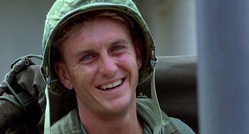 Movie still from “Good Morning, Vietnam” (1987), directed by Barry Levinson – A man wearing a hat smiling for the camera; Close Up shot, Low angle