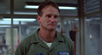 Movie still from “Good Morning, Vietnam” (1987), directed by Barry Levinson – A person wearing a military uniform; Close Up shot, Low angle