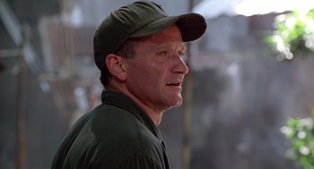 Movie still from “Good Morning, Vietnam” (1987), directed by Barry Levinson – A person wearing a hat; Close Up shot, Low angle