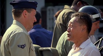 Movie still from “Good Morning, Vietnam” (1987), directed by Barry Levinson – Two men talking to each other in front of a group of people; Close Up shot, Over the shoulder angle